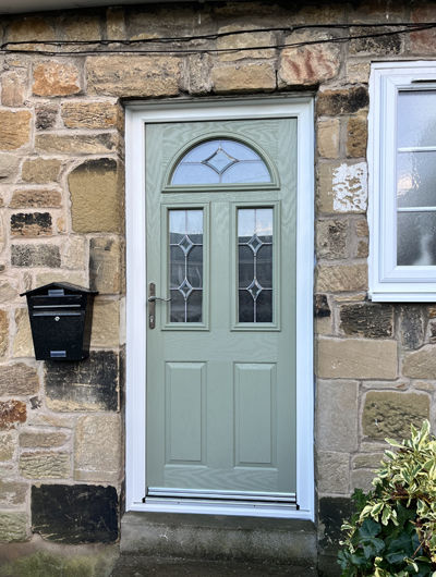 Composite front door in olive with arched glass and bevels